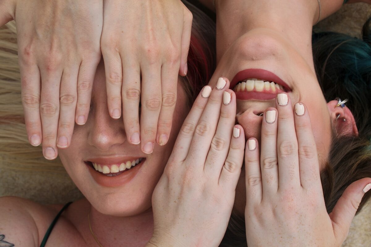 a group of women with their hands on their faces